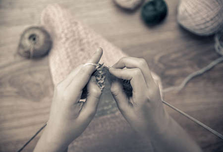 baby girl knitting pink scarf close up on a wooden table.の写真素材