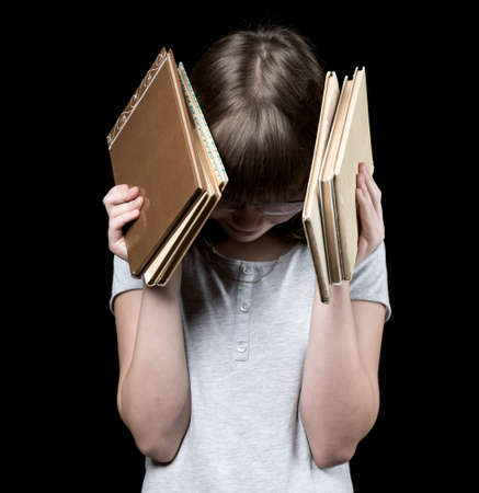 baby girl in glasses with book on the dark backgroundの写真素材