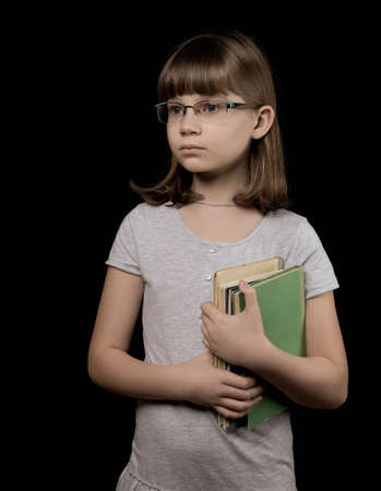 baby girl in glasses with book on the dark backgroundの写真素材
