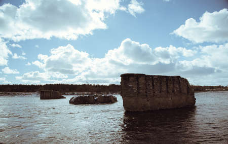 support the destroyed bridge on the river against the blue skyの写真素材