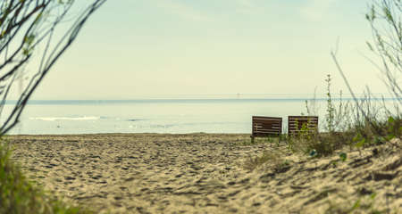Couple of beach chairs on sea coast on the background of blue skyの写真素材