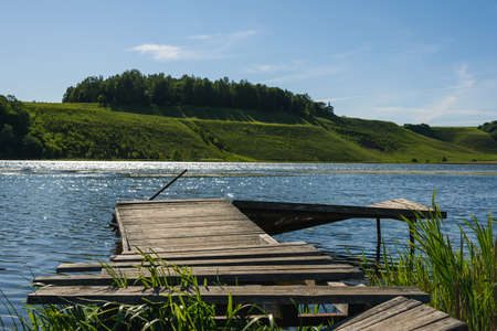 old wooden jetty at spring lake on a blue sky backgroundの写真素材