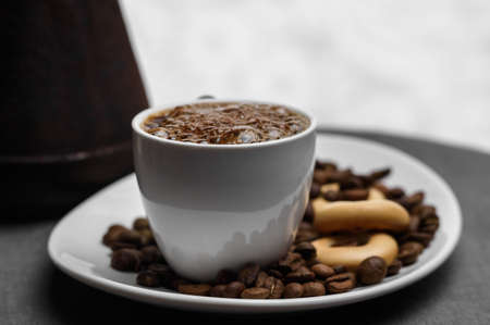 Cup of coffee, a Turk and grains on a gray background