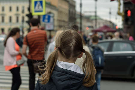 girl child stands with his back to the crosswalkの写真素材