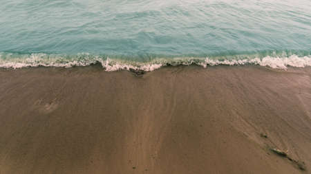 the wave of bright blue color incident on the beach