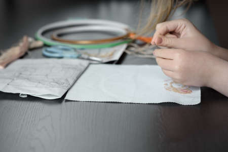 cross stitching baby hand closeup on the background of the Hoop