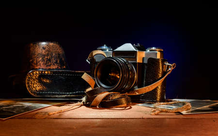 old vintage camera, photos and film on a dark background