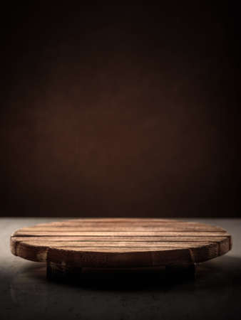 Wooden round stand for the bitterness of food on a dark background, place for inscription, coverの写真素材