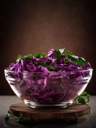 Salad of red cabbage in glass transparent bowl on dark backgroundの写真素材