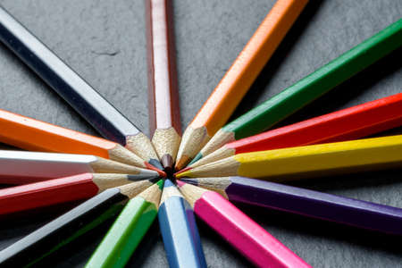 Many different colored pencils neatly folded on wooden table backgroundの写真素材
