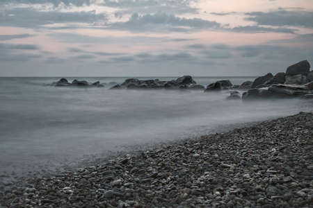 Sea stone breakwater against the sea and evening sky