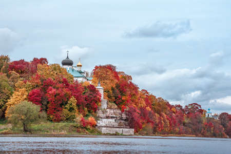 Ancient Christian monastery in colorful autumn Park on the banks of the river