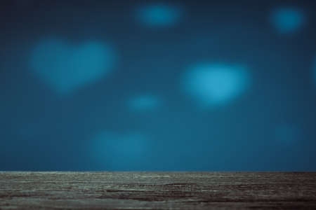 Empty brown wood table top on blue background with white transparent hearts. Used for display or...
