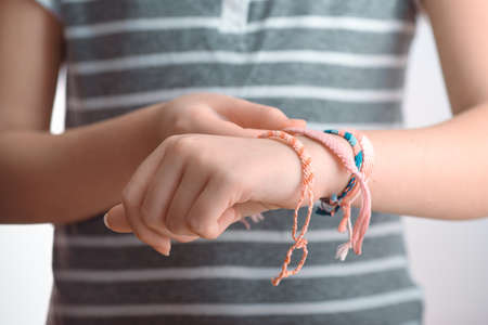Horizontal toned shot of a female hand wearing braided braceletsの写真素材