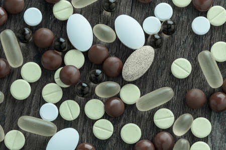 Horizontal shot of set of drugs for treatment on a dark wooden background. Medical concept.