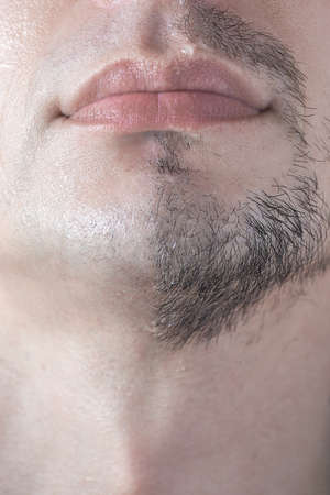 A mans half-shaved chin. White young man shaving.の写真素材