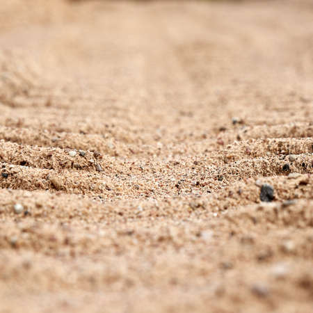 Background tire tracks of cars on the sand closeup. Part of the background is blurred.の写真素材