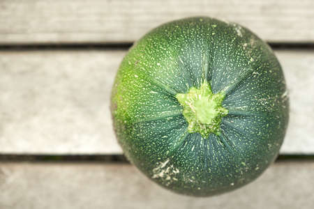 Green round zucchini isolated on wooden background.の写真素材