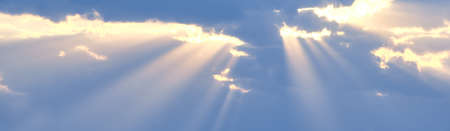 Horizontal shot of sun's rays break through the blue clouds. The background of the sky.