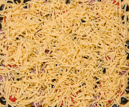 Horizontal shot of closeup of a home made raw pizza with cheese, red onions, basil and tomato sauce.の写真素材