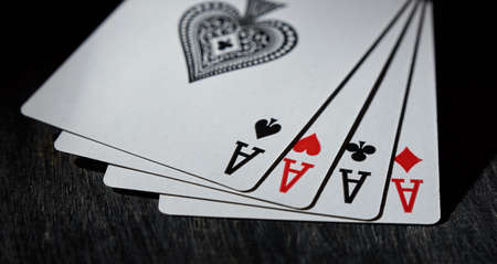Horizontal shot of playing card. Four aces close-up on a black background.の写真素材
