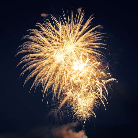 Square shot of yellow fireworks in the dark sky. Festive concert.の写真素材