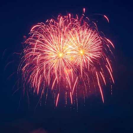 Square shot of red fireworks in the dark sky. Festive concert.