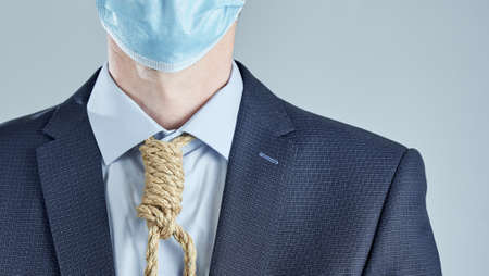 Horizontal shot of businessman in medical mask with rope around his neck on gray background.の写真素材