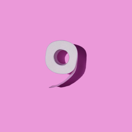 Square shot of roll of toilet paper close-up isolated on pink background. top view. Toilet paper with a shadow in the form of number nine.の写真素材