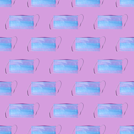 Seamless pattern of many medical masks on the pink colored background to cover the mouth and nose...