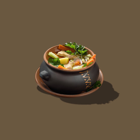 Square shot of meat soup with vegetables in a black baking pot isolated on a brown background.
