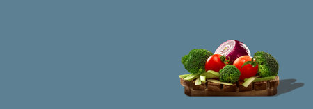 Healthy vegetables on round wooden board isolated on gray background. Photo with copy space.の写真素材