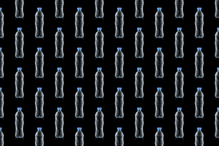 Horizontal seamless pattern of water bottles are isolated on a black background. world water day. Pollution, environmental protection concept. Transparent bottles with blue lids.の写真素材