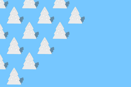 Horizontal seamless pattern of white Christmas tree decorations with shadow isolated on blue background. Photo with copy space.の写真素材