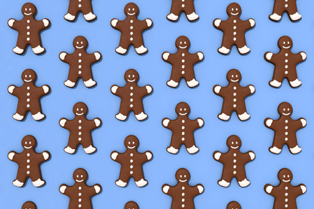 Horizontal seamless pattern of gingerbread man on blue background. holiday decoration. Festive decoration. Brown cookies collection isolated on blue seamless surface.の写真素材