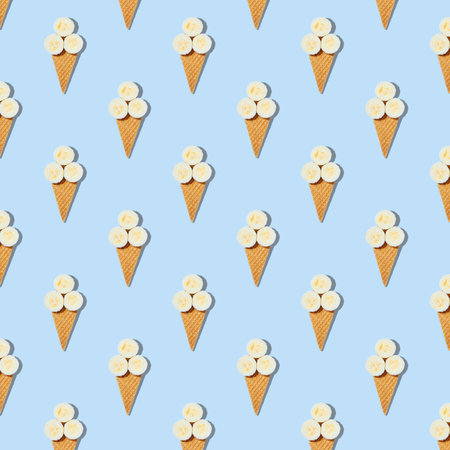 Square seamless pattern of stylish mockup with banana slices in an ice cream waffle cone on a pastel blue background. Creative healthy food concept.の写真素材