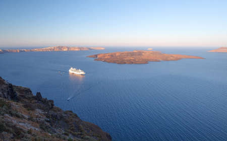 cruise liner motoring into the caldera below the cliffs of the capital city of fira on the greek island of santoriniの写真素材