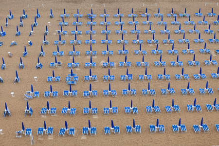 Rows of blue and white parasols and sunbeds on the beach at Lido di Jesolo, Italy.の写真素材