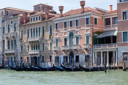 View of the Grand Canal with gondolas and colorful facades of old medieval houses in Venice, Italy. Venice is a popular tourist destination of Europe.の写真素材