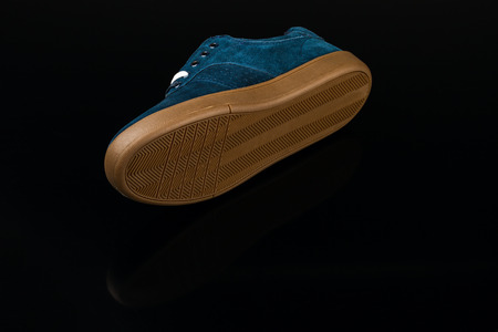 dark blue velvet man's shoe on black backgroundの写真素材