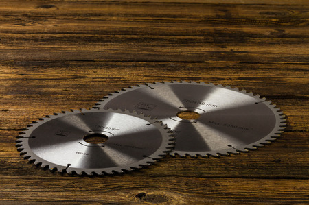 circular saw blades on wooden backgroundの写真素材