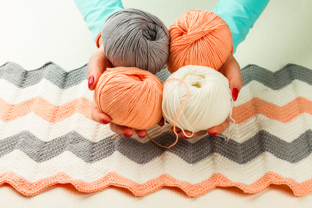rolls of soft knitting yarn, knitting, female hands on white background