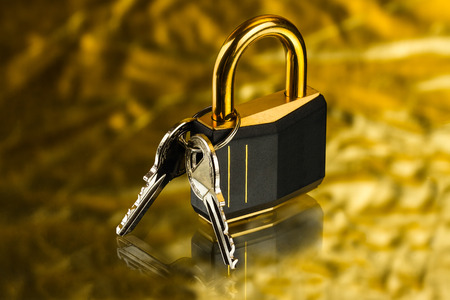 hinged lock with keys on golden backgroundの写真素材