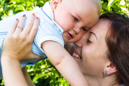 charming caucasian baby boy with mother in garden