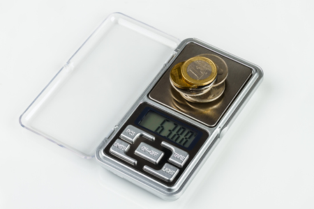digital jewellery scales with coins on white backgroundの写真素材