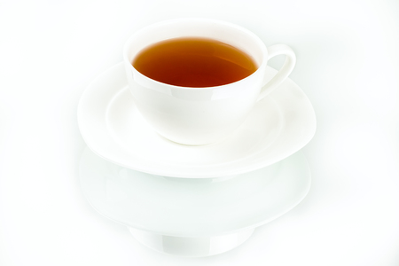 white ceramic saucer with cup of tea on white backgroundの写真素材