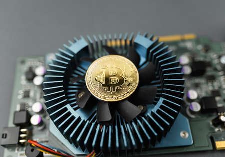 bitcoin on the video card, bitcoin coin on the table near the computer board, a lot of free space