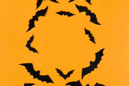 halloween decorations concept, many black paper bats on orange background, table top view, lots of free spaceの写真素材