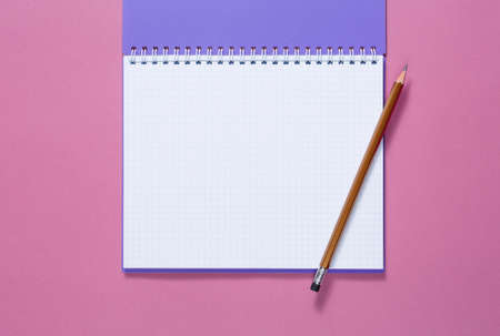 top view of a open notebook with pencil on a purple background, school notebooks with a spiral...