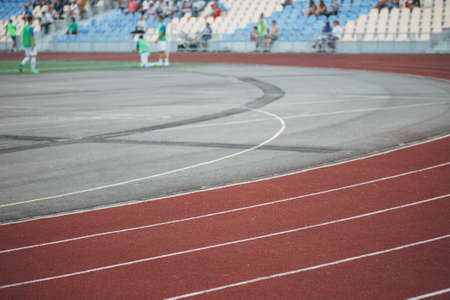 Running track for the athletes in the stadium during the competition, a red bike path in the city...